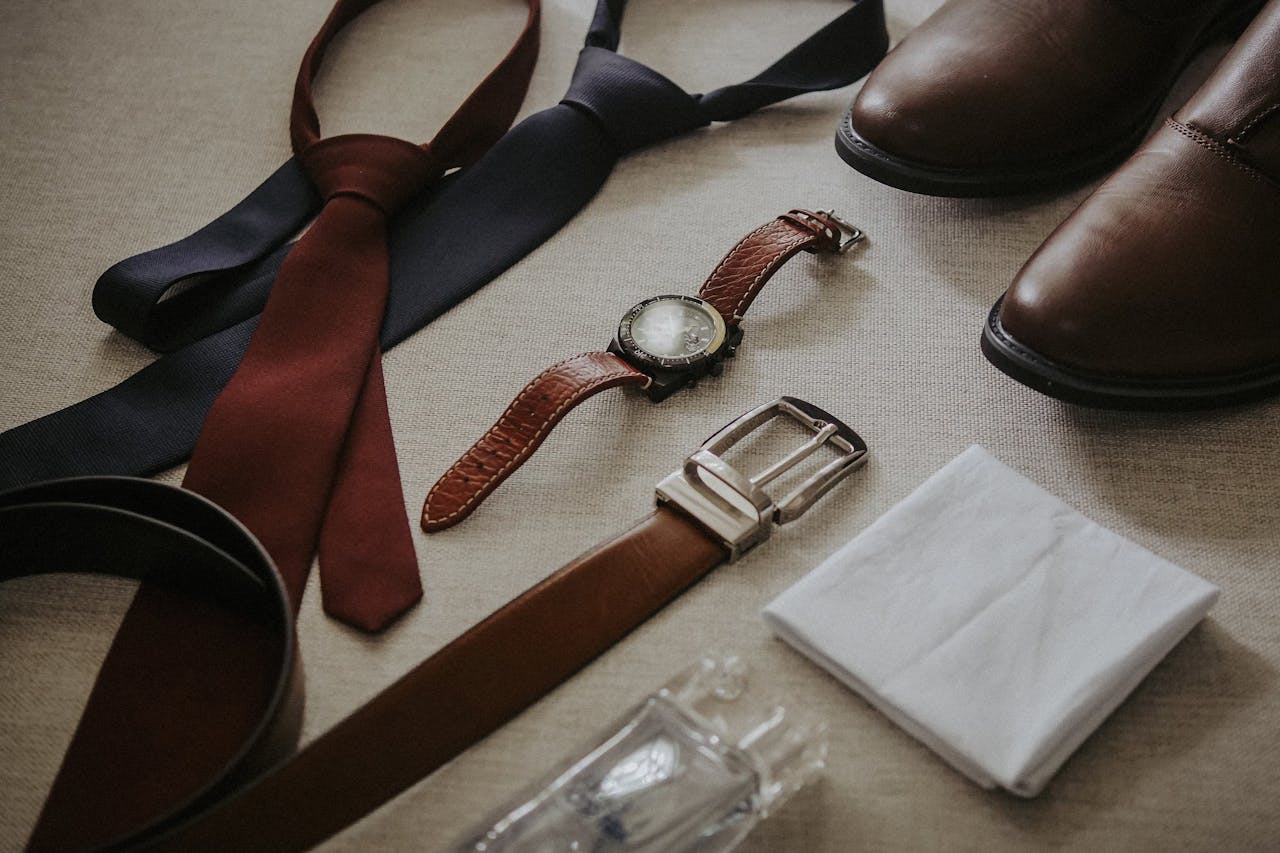 Stylish men's accessories including ties, watch, shoes, belt, and handkerchief.
