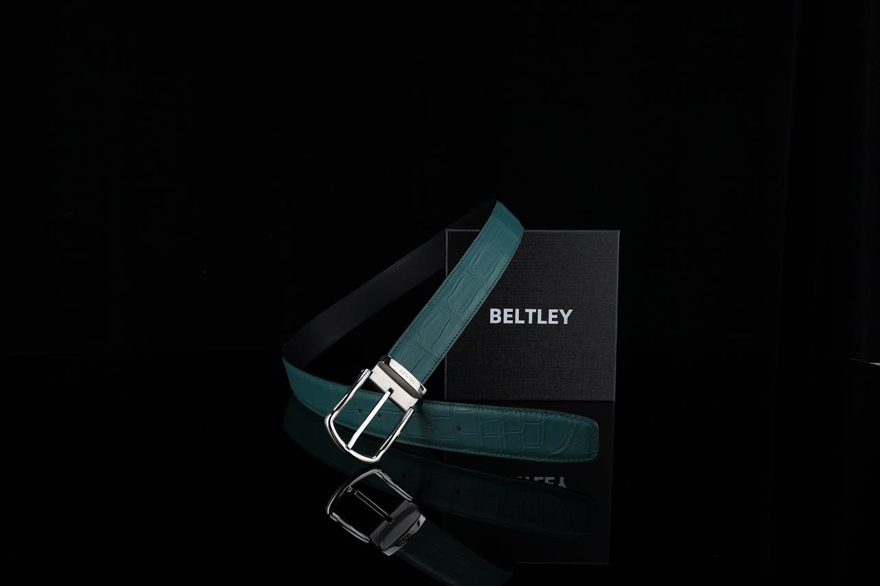 Elegant green belt with silver buckle displayed against a black background, featuring the brand name 'Beltley'.